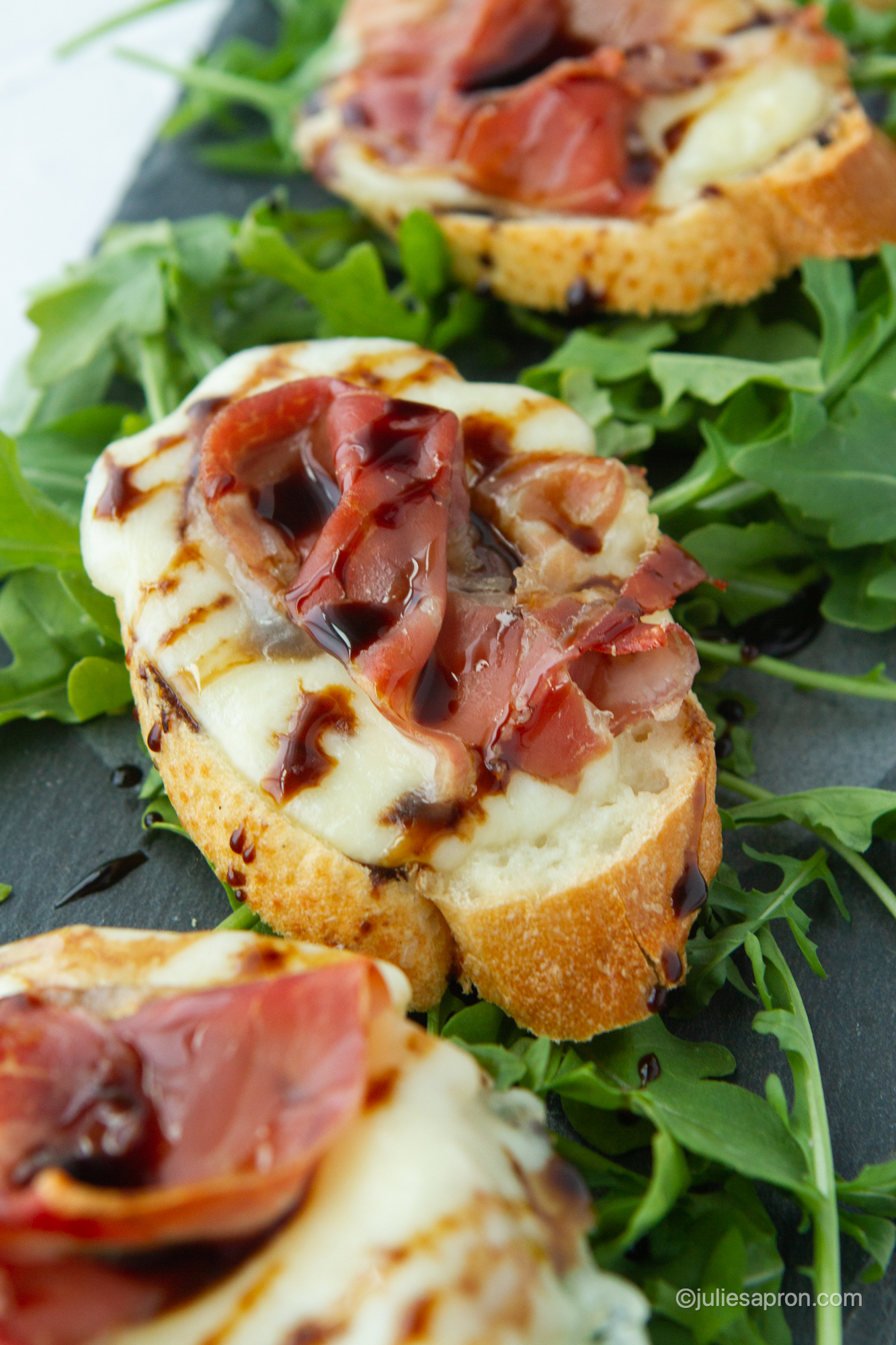 prosciutto crostini melts topped with a balsamic glaze