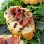 prosciutto crostini melts topped with a balsamic glaze