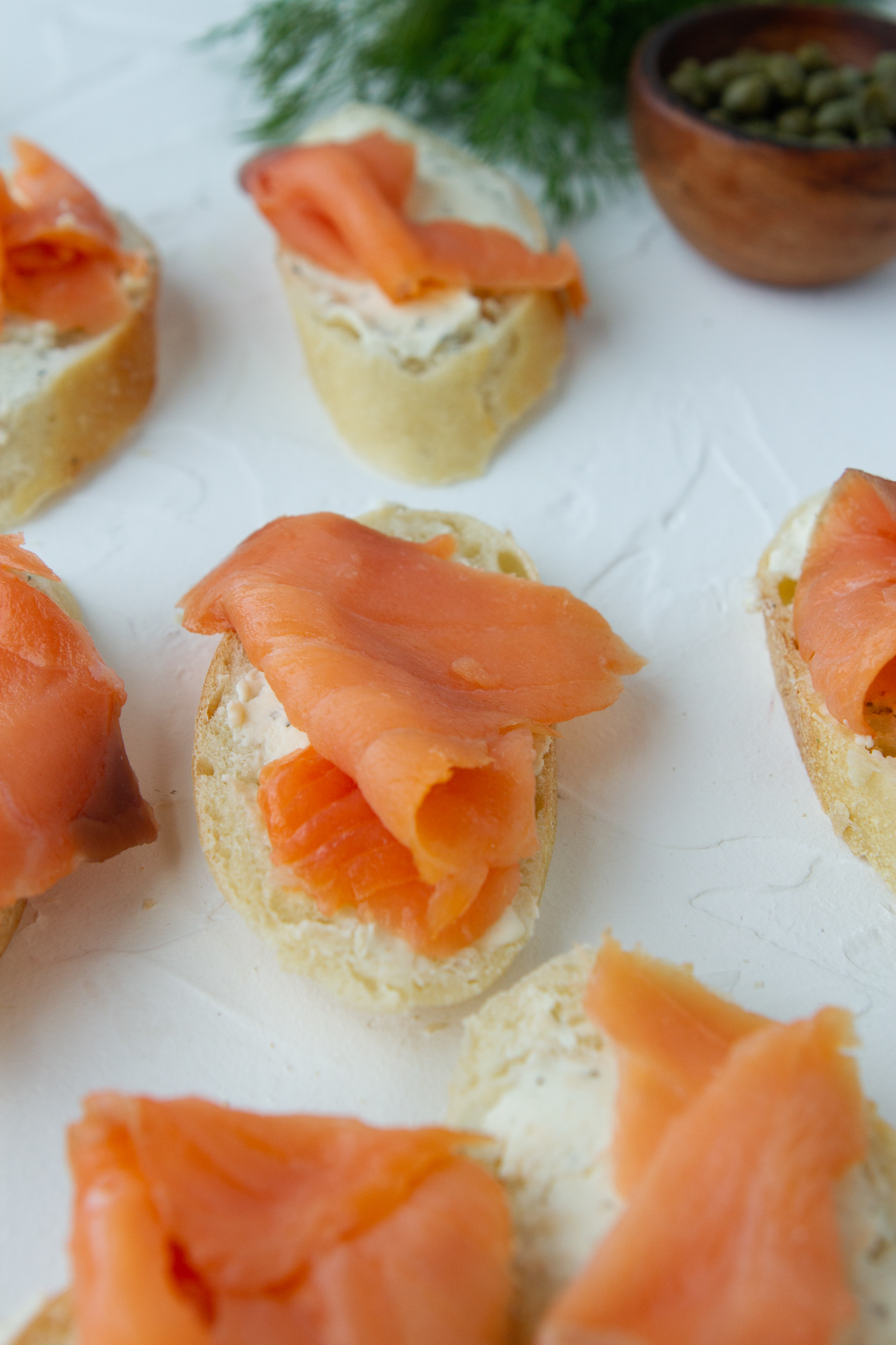 smoked salmon placed onto crostini slice