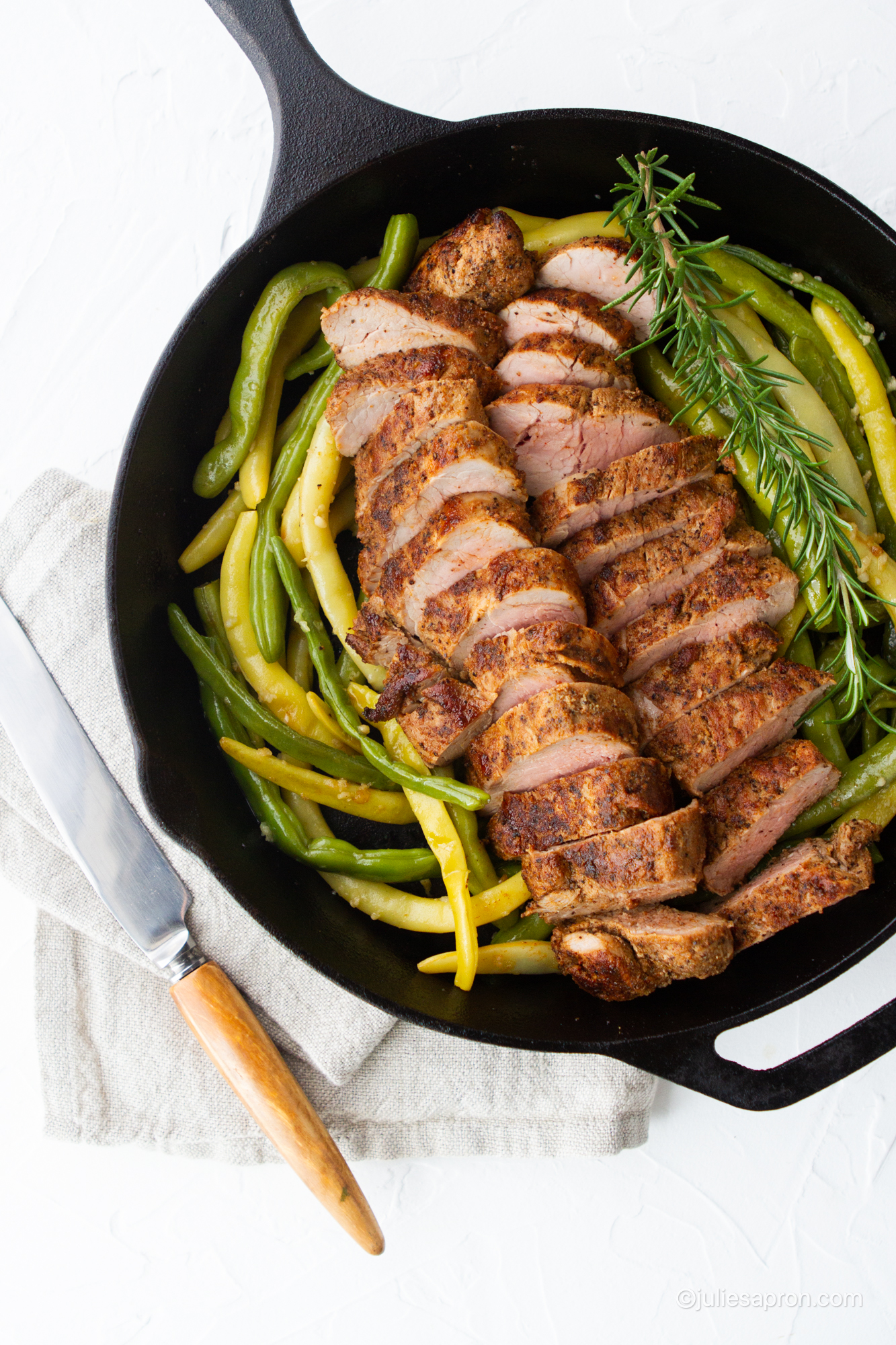 cut tenderloin laying on green beans