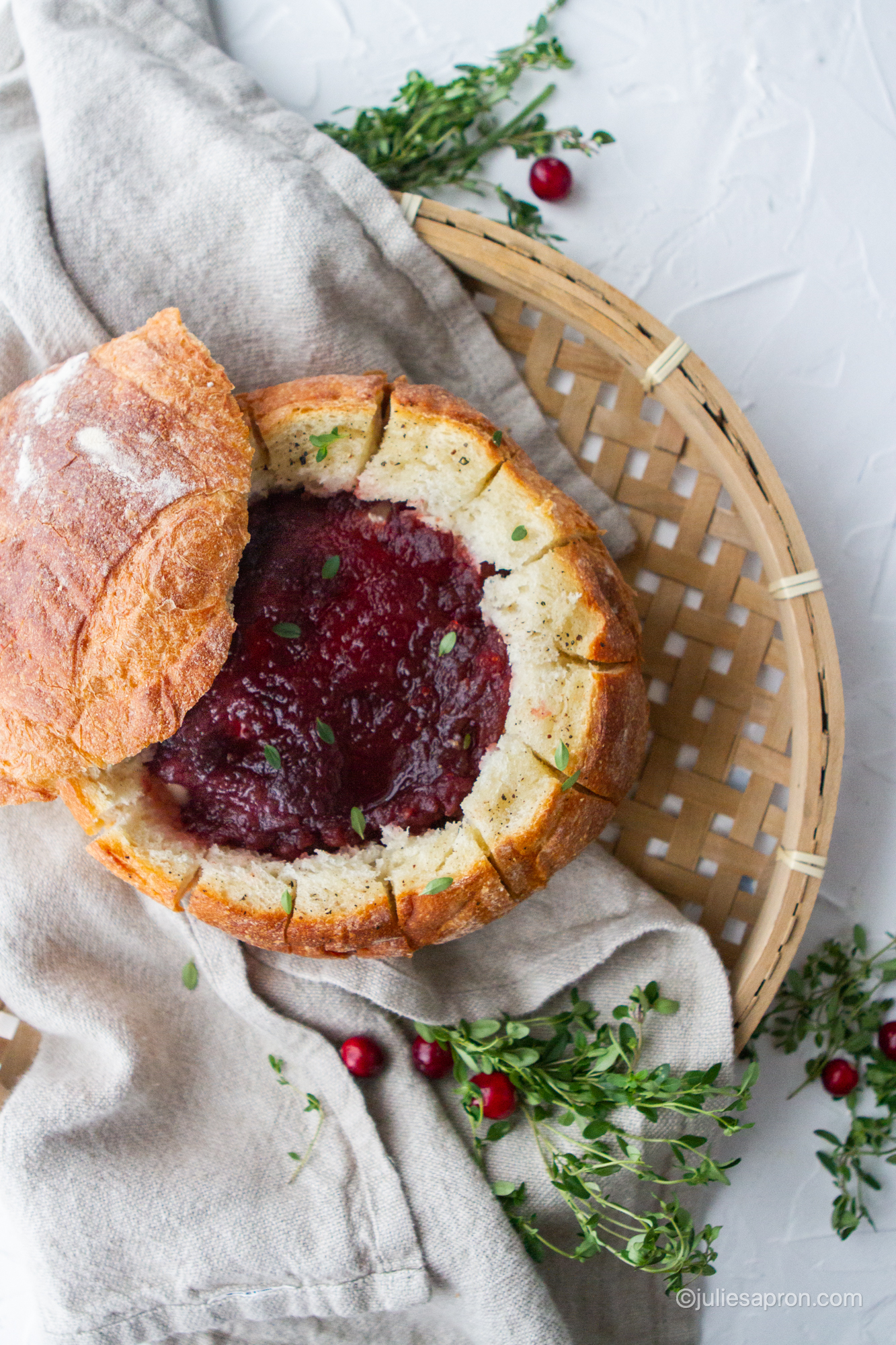 brie in a bread bowl topped with cranberry sauce