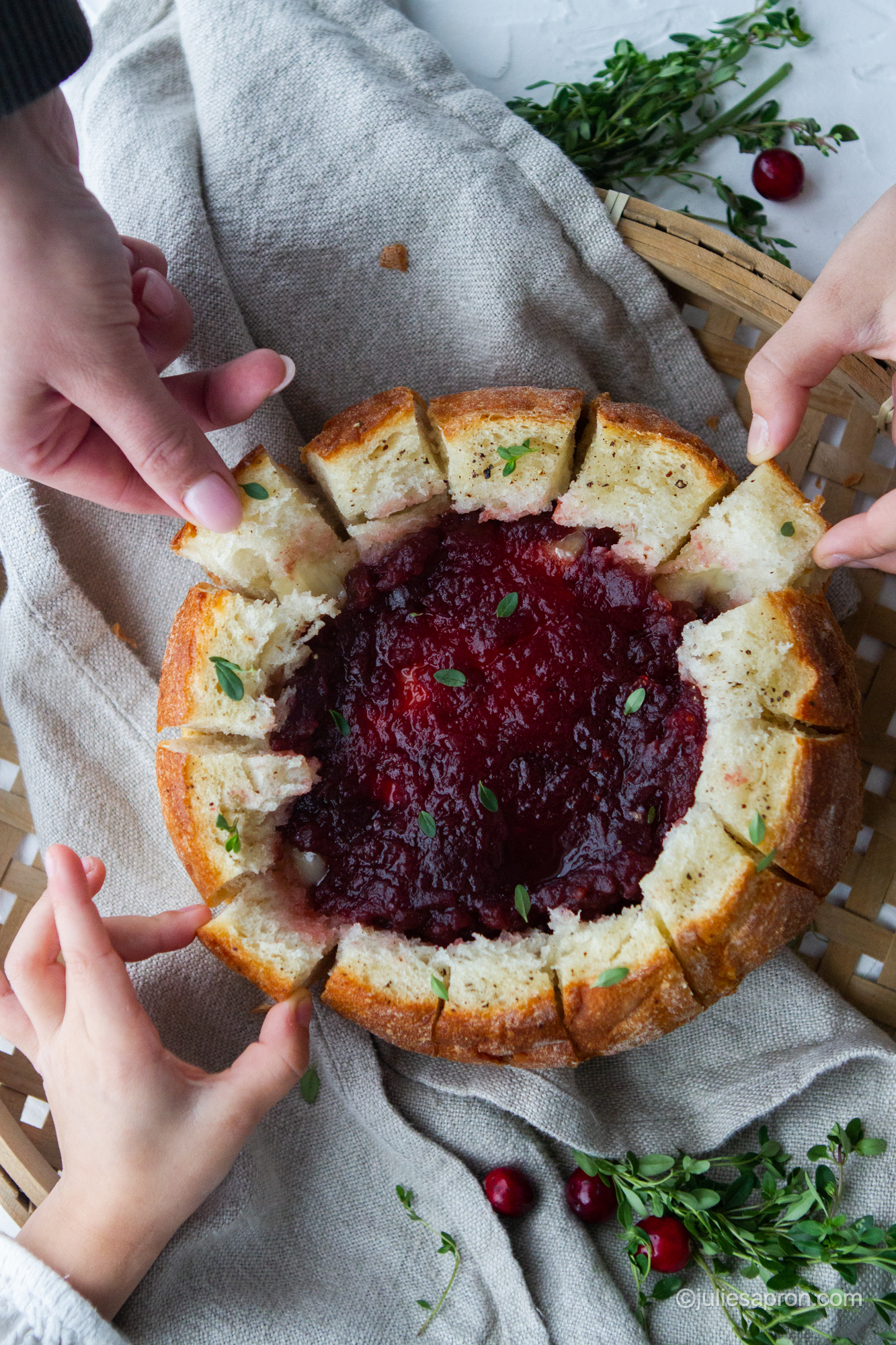 close up of bread bowl with hands in picture