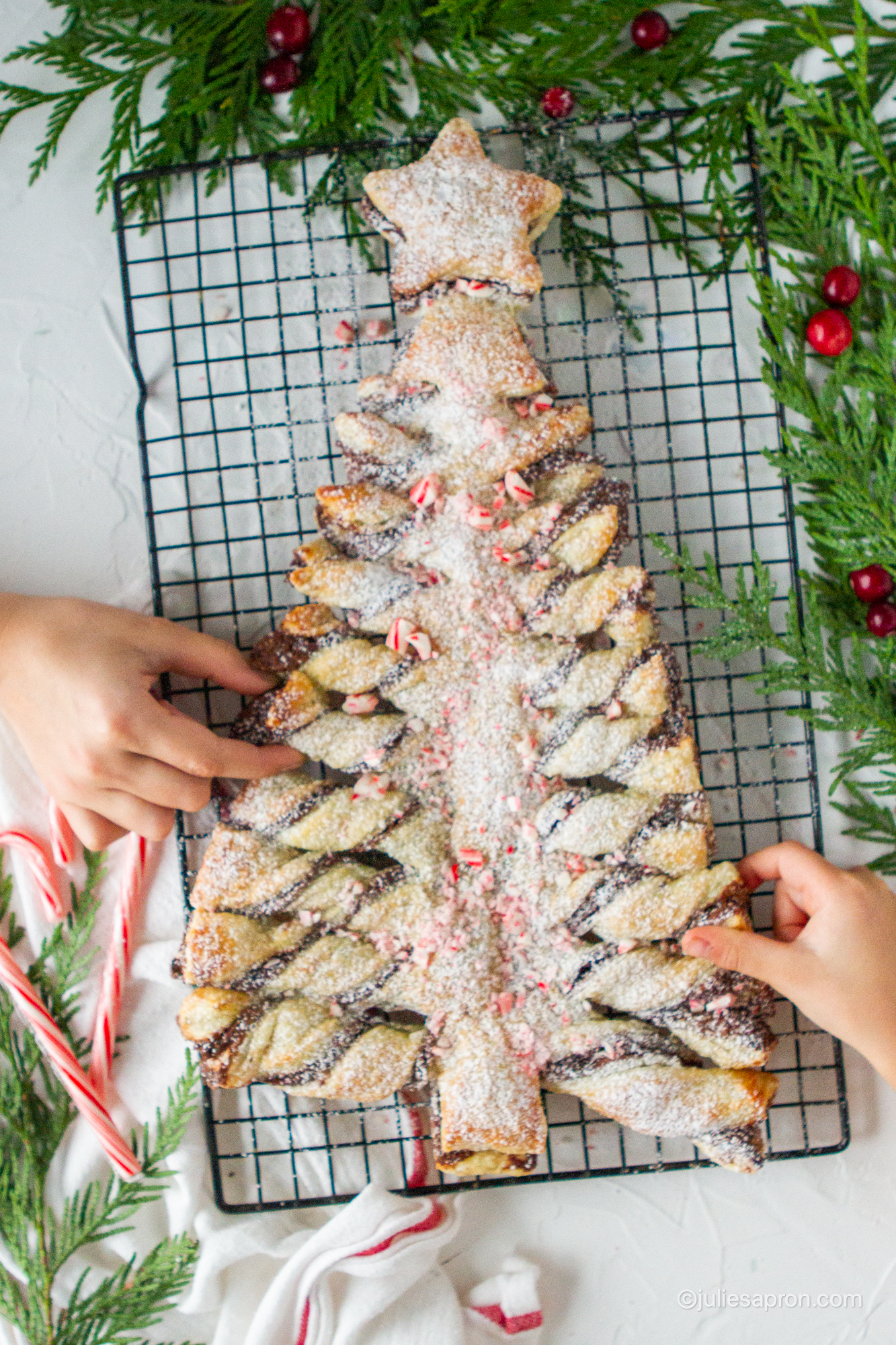 puff pastry Christmas tree with hands pulling branches