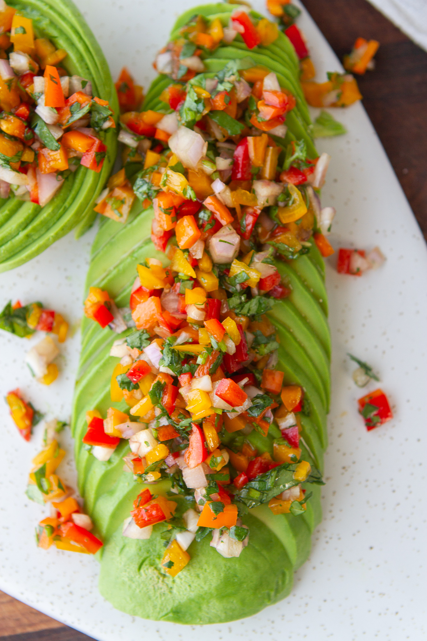 avocado sliced horizontally topped with salsa