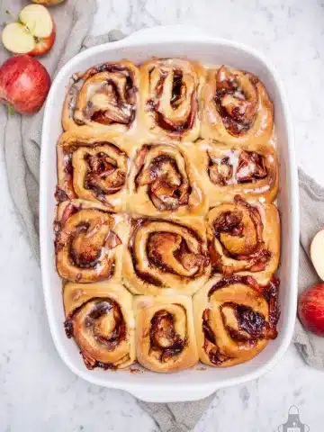 apple pie cinnamon rolls in a white casserole dish