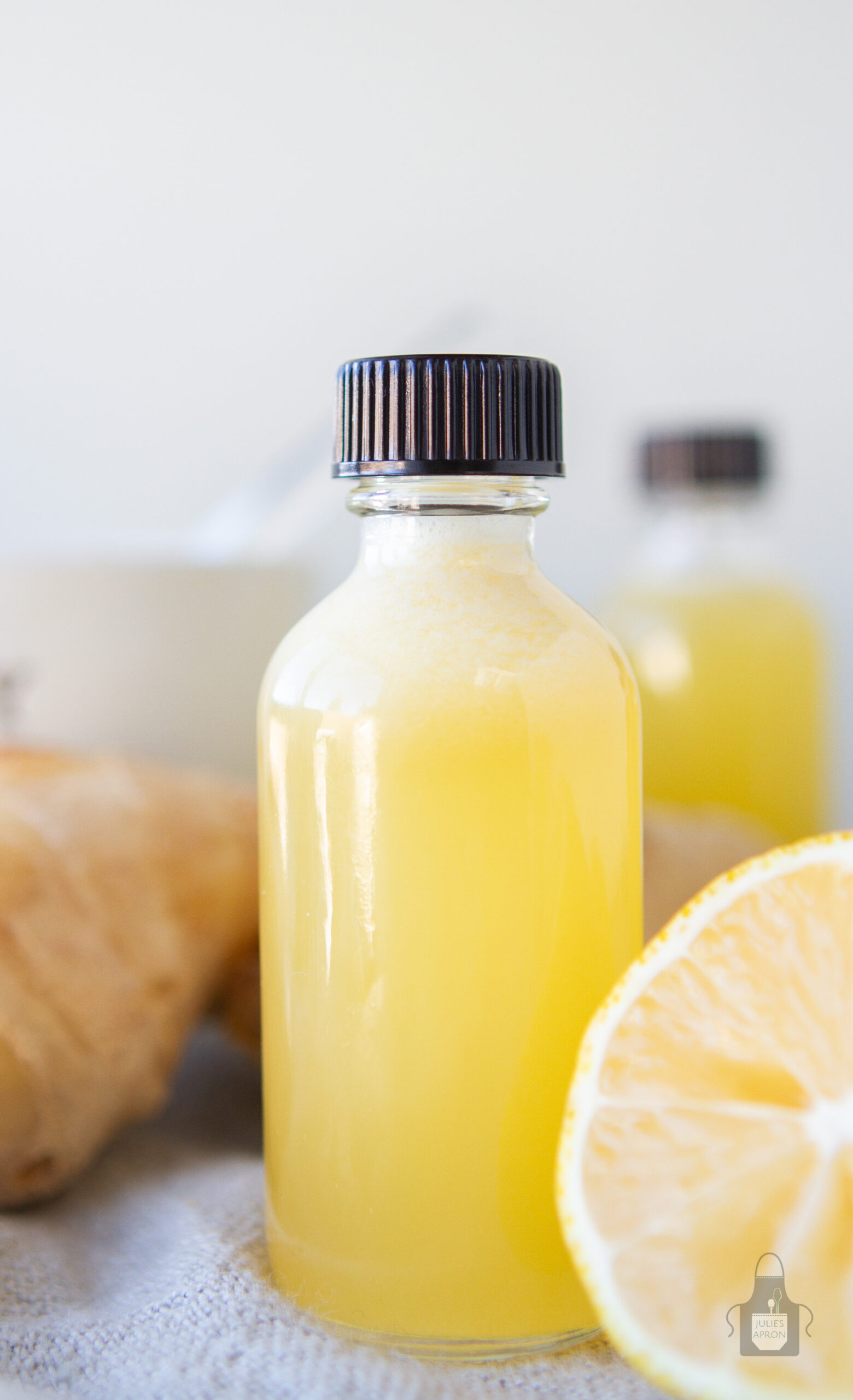 glass bottle with yellow liquid