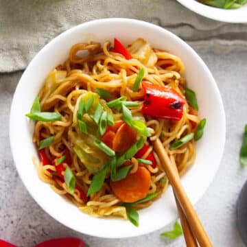 vegetables and yakisoba noodles in a bowl with chopsticks