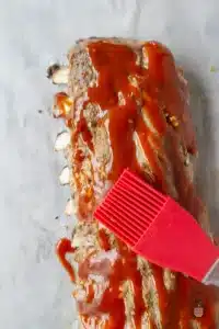 brushing bbq sauce onto ribs