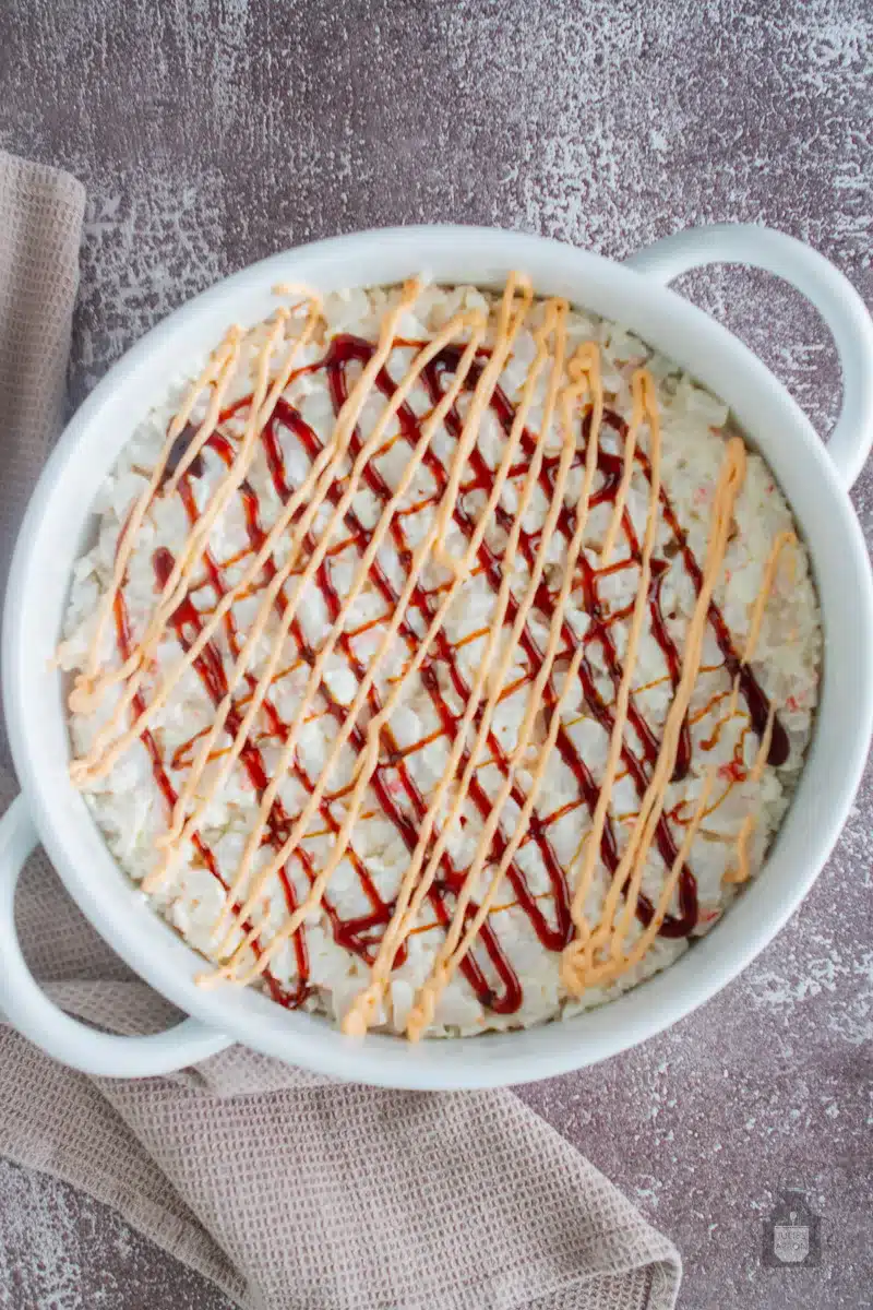 spicy mayo and eel sauce drizzled onto sushi bake