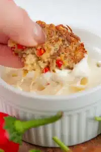 crab cake dipping into garlic aioli