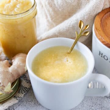 organic lemon ginger honey tea in a white tea cup